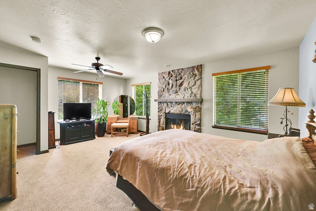 655 Ogden Canyon Road Ogden, UT 84401 - Photo 18 of 50 Spacious room featuring a stone-clad fireplace, ceiling fan, carpet flooring, and multiple windows with blinds