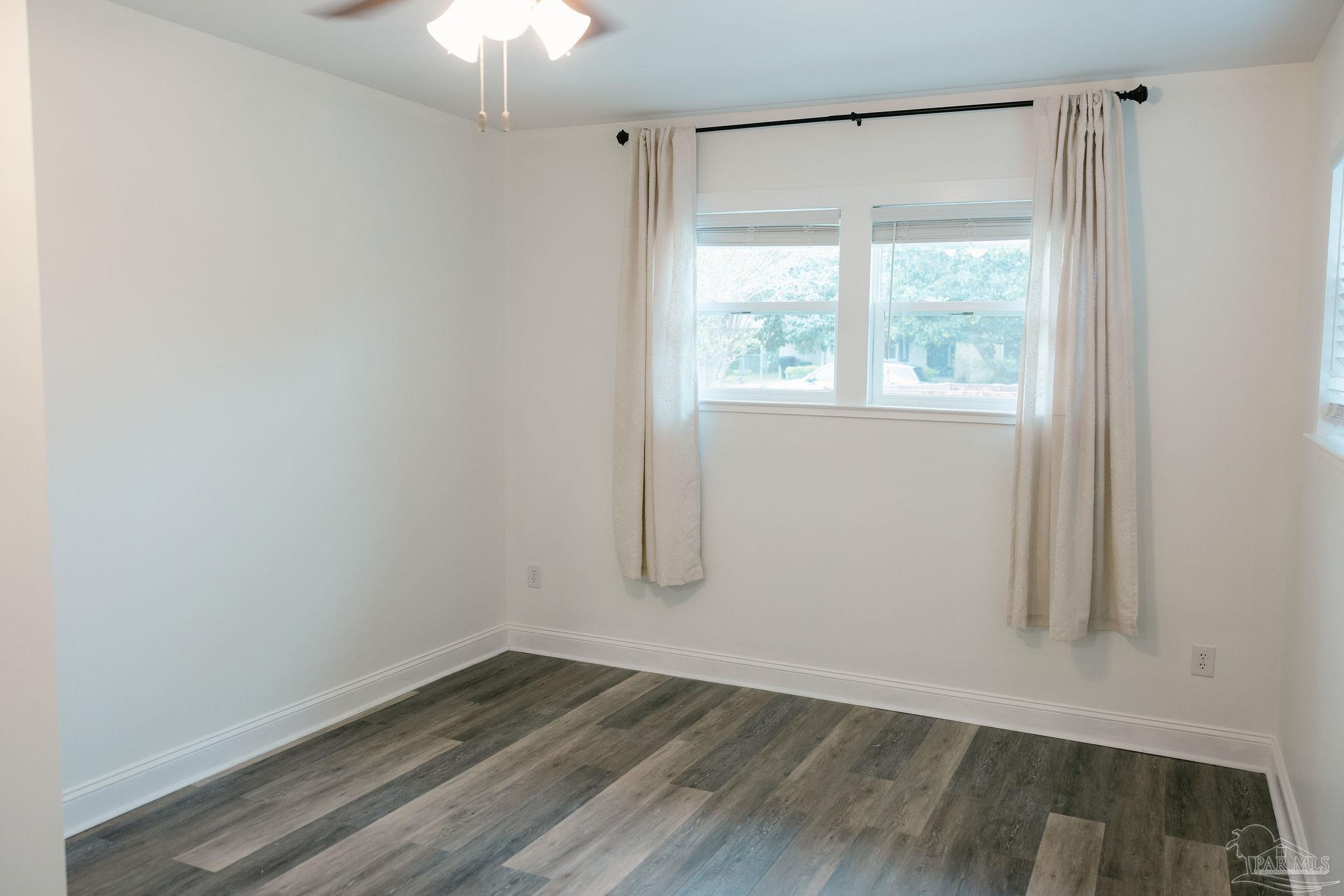 5580 Homewood Road Pensacola, FL 32504 - Photo 11 of 28 a view of an empty room with wooden floor and a window