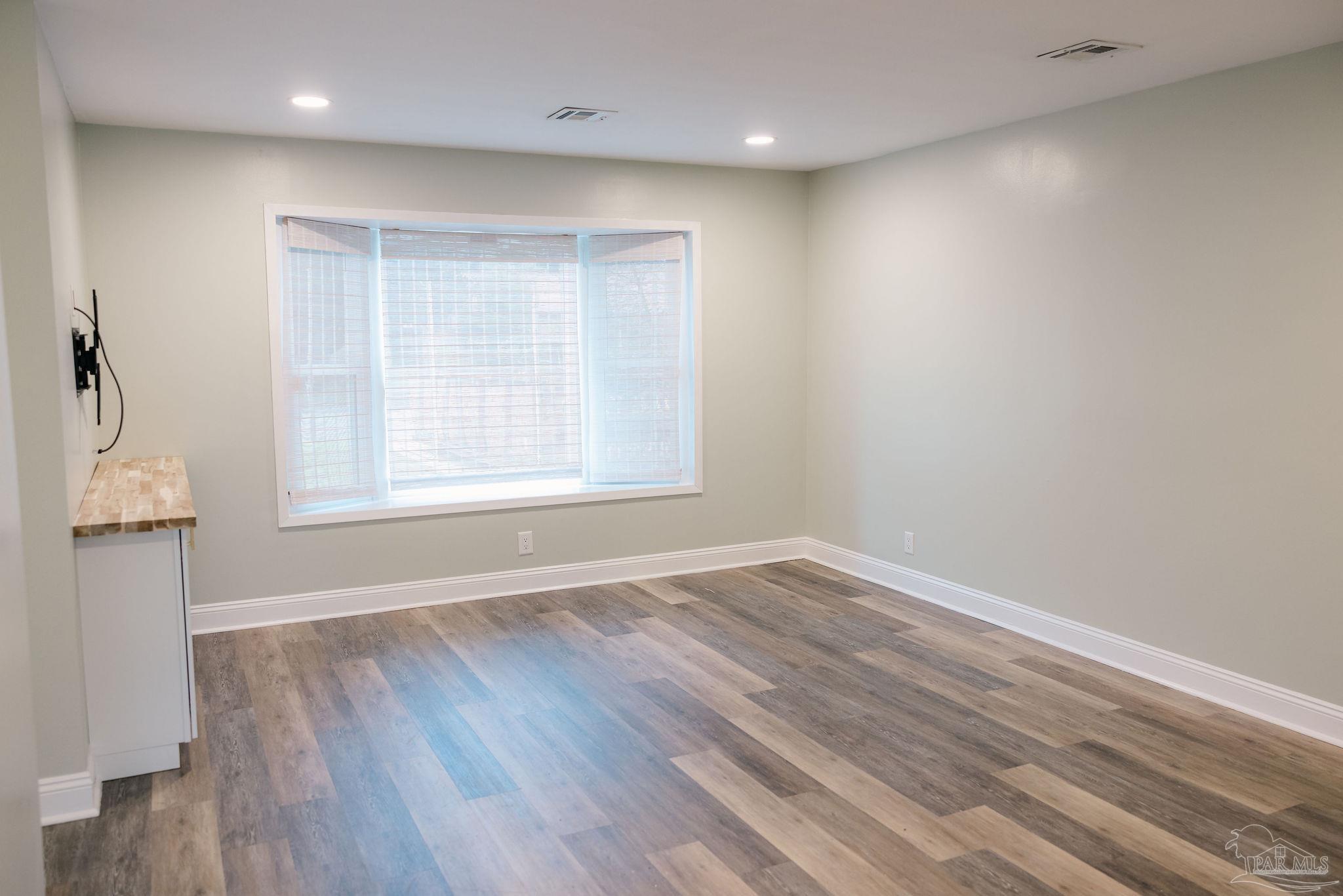 5580 Homewood Road Pensacola, FL 32504 - Photo 13 of 28 an empty room with wooden floor and windows