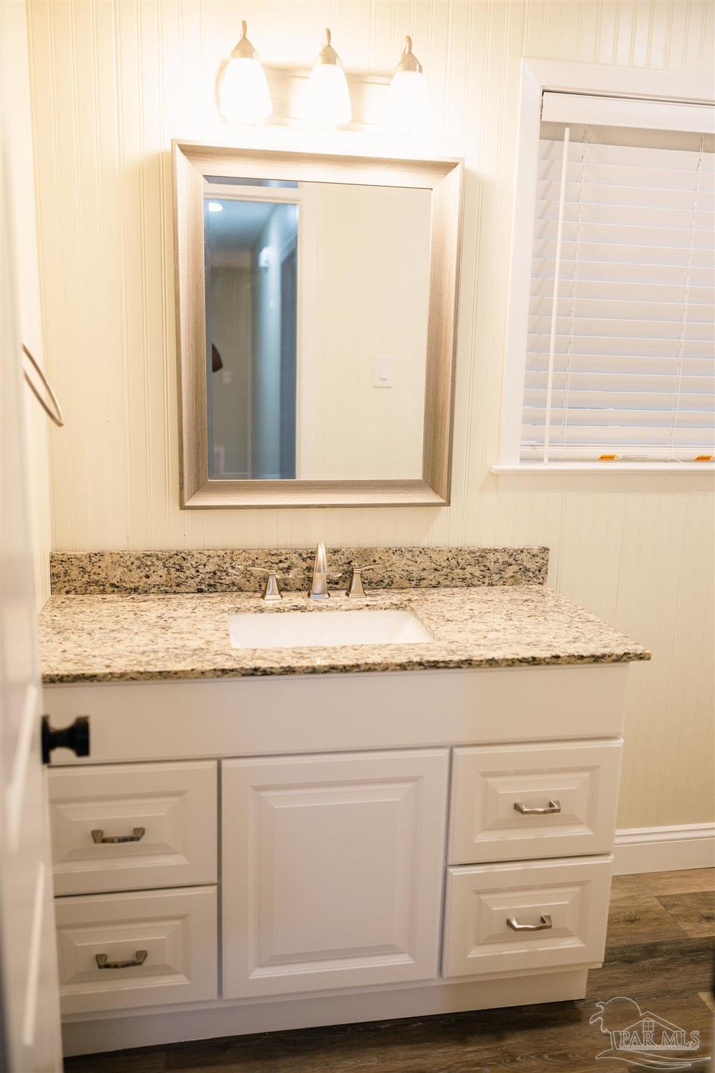 5580 Homewood Road Pensacola, FL 32504 - Photo 24 of 28 a bathroom with a granite countertop vanity and mirror