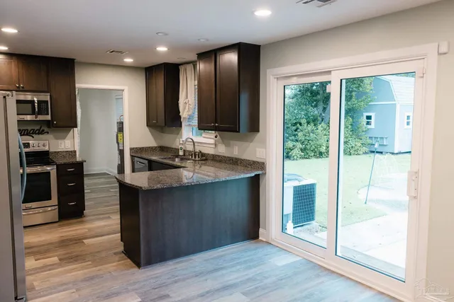 a kitchen with stainless steel appliances granite countertop a refrigerator and a stove