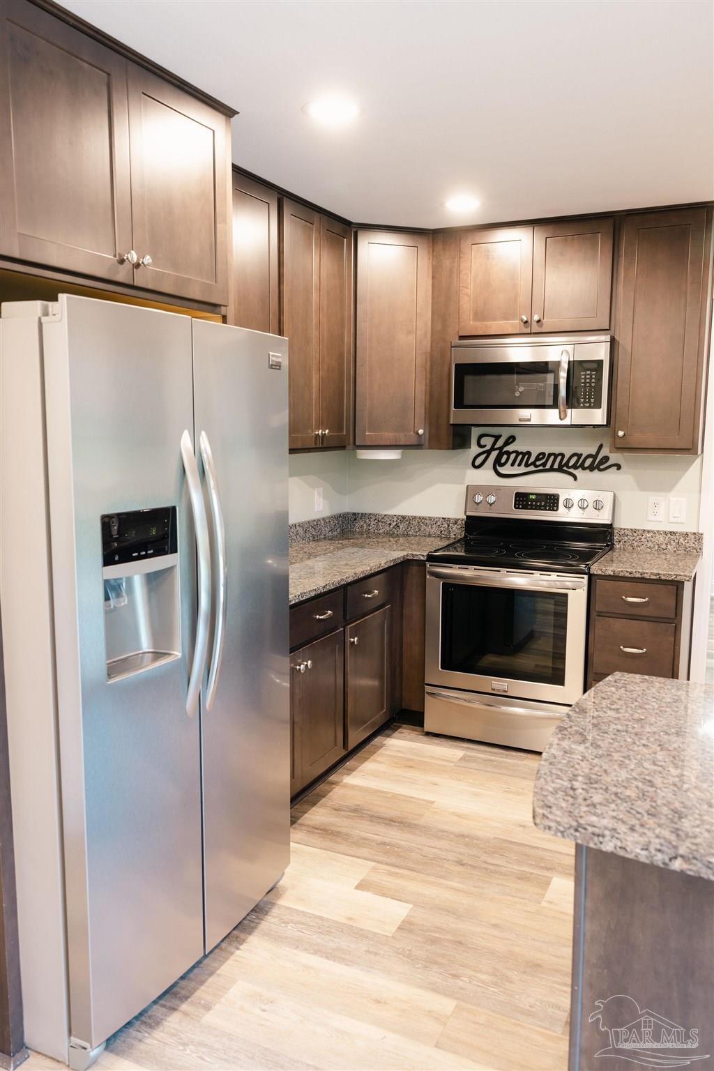5580 Homewood Road Pensacola, FL 32504 - Photo 7 of 28 a kitchen with stainless steel appliances granite countertop a stove a refrigerator and a sink