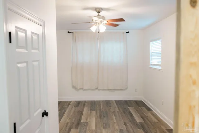 a view of a small space with wooden floor and a window