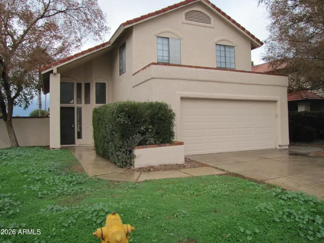 a view of a white house with a big yard and large tree