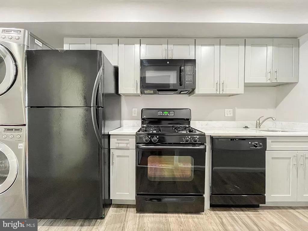 1240 Simms Place Northeast Washington, DC 20002 - Photo 4 of 8 a kitchen with a refrigerator stove and white cabinets