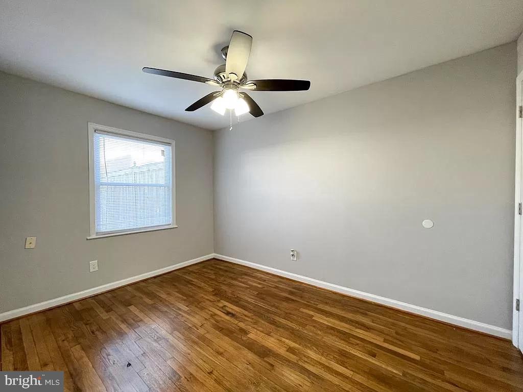 1240 Simms Place Northeast Washington, DC 20002 - Photo 5 of 8 an empty room with wooden floor fan and windows