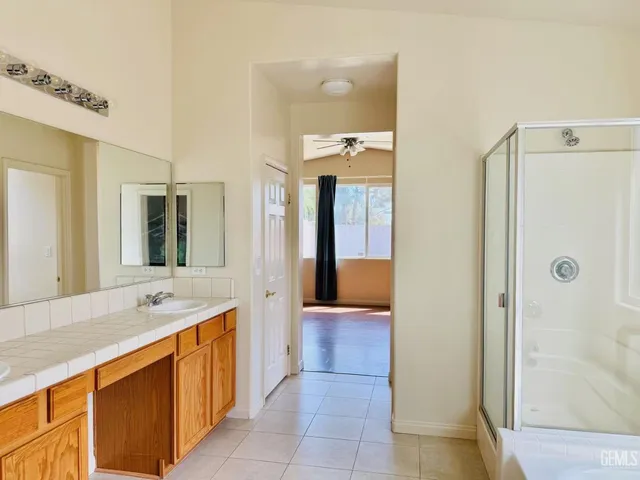 a spacious bathroom with a granite countertop sink mirror and shower