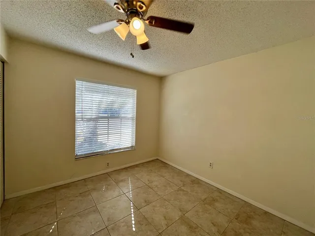 an empty room with a window and a fan