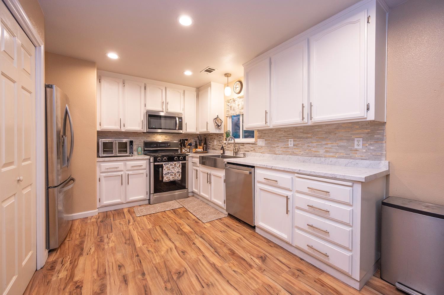 4568 Roadrunner Drive Ione, CA 95640 - Photo 23 of 56 a kitchen with white cabinets stainless steel appliances and sink