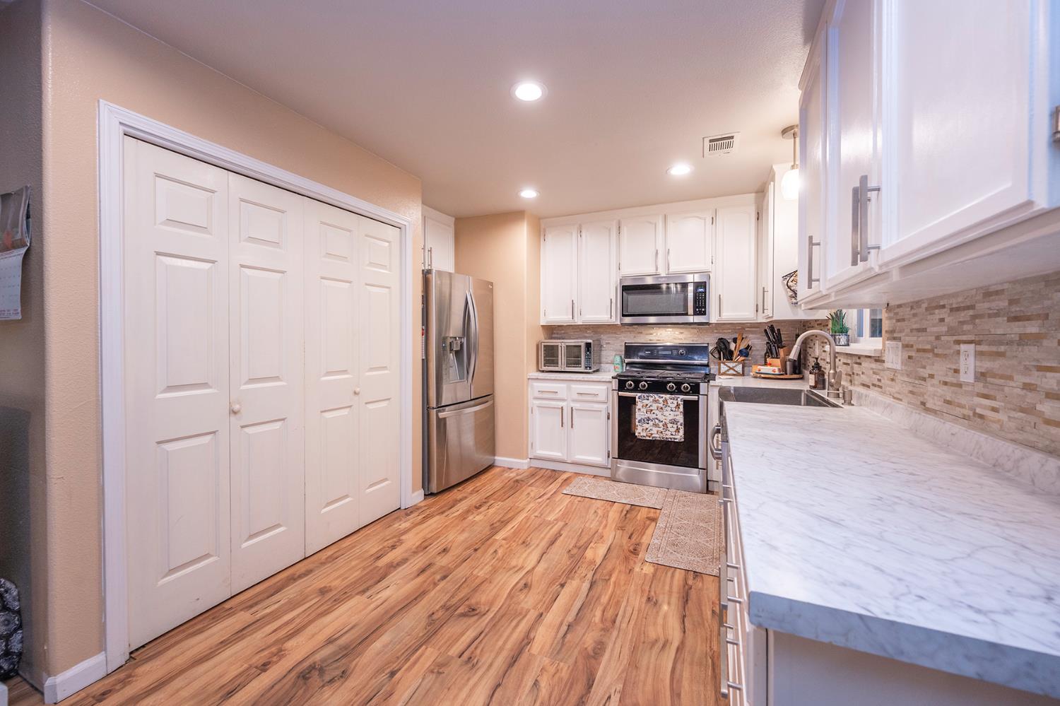 4568 Roadrunner Drive Ione, CA 95640 - Photo 24 of 56 a kitchen with stainless steel appliances granite countertop a refrigerator stove top oven and cabinets