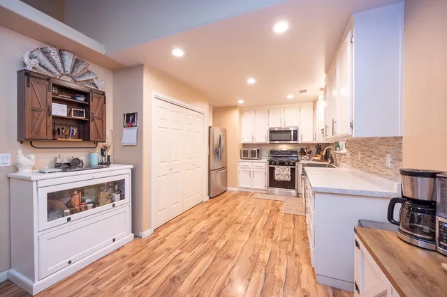 a open kitchen with stainless steel appliances granite countertop a stove and a refrigerator
