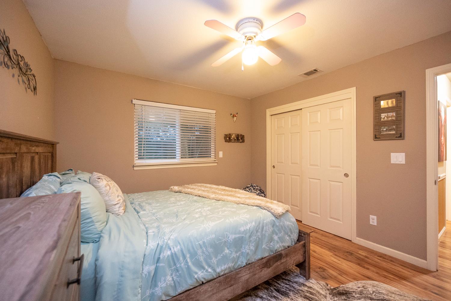 4568 Roadrunner Drive Ione, CA 95640 - Photo 41 of 56 a bedroom with a large bed and a chandelier