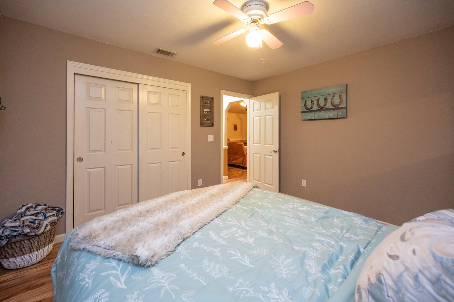 4568 Roadrunner Drive Ione, CA 95640 - Photo 42 of 56 a bedroom with a large bed and a chandelier
