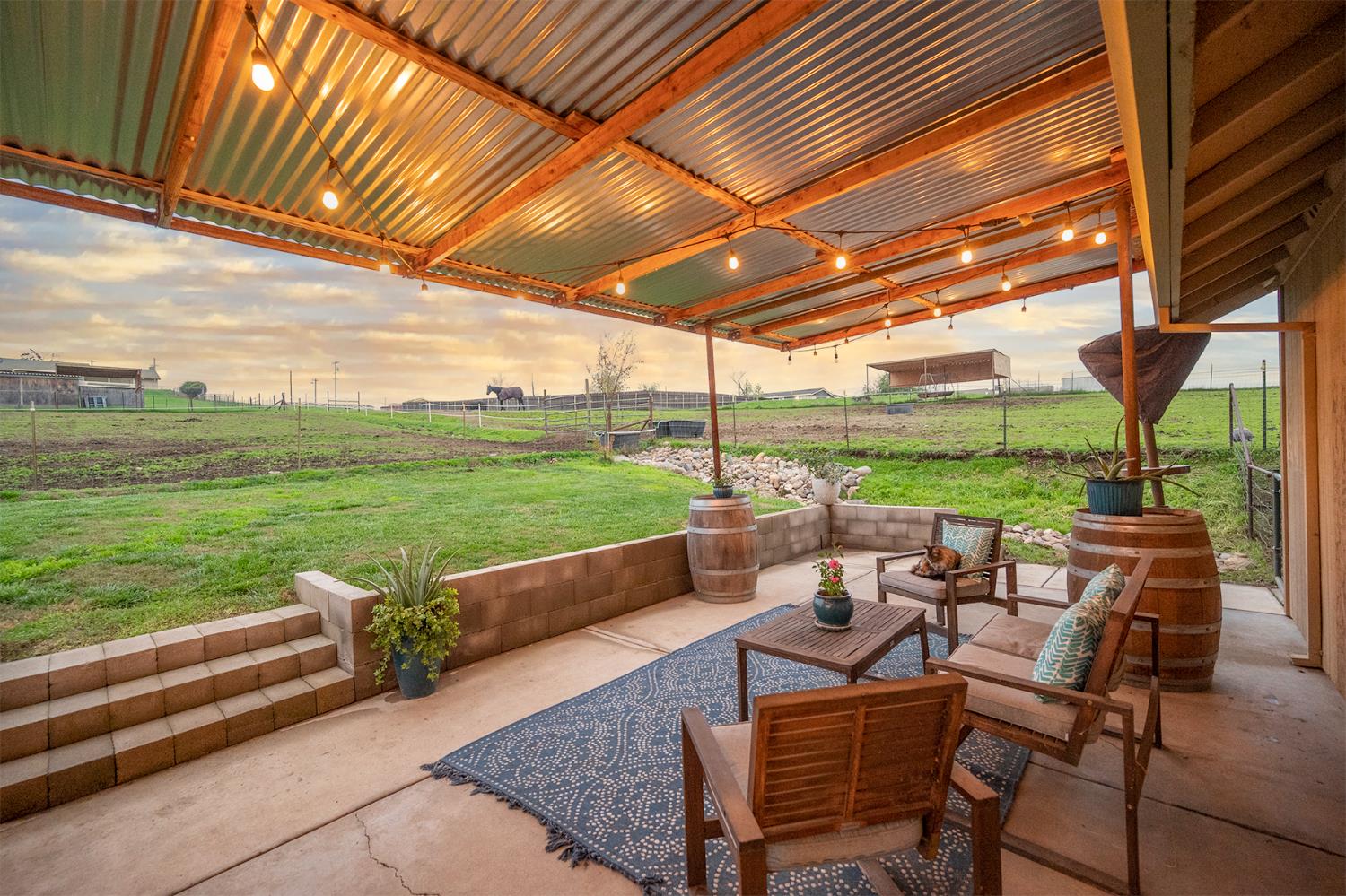 4568 Roadrunner Drive Ione, CA 95640 - Photo 48 of 56 a view of a patio with dining table and chairs next to a yard