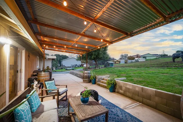 a view of a chairs and table in the back yard of the house