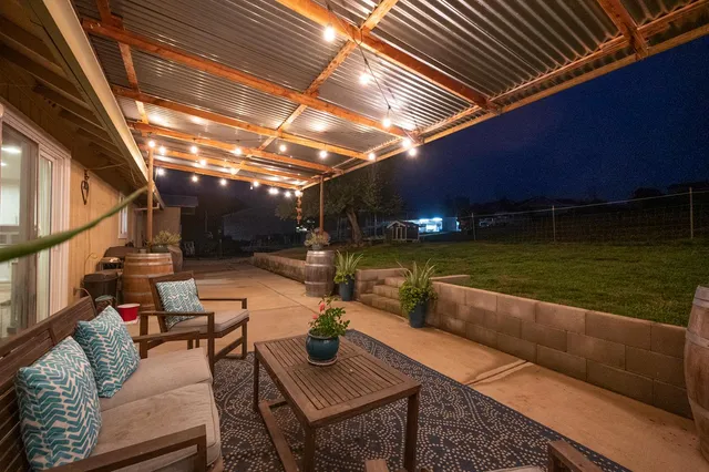 a backyard of a house with table and chairs