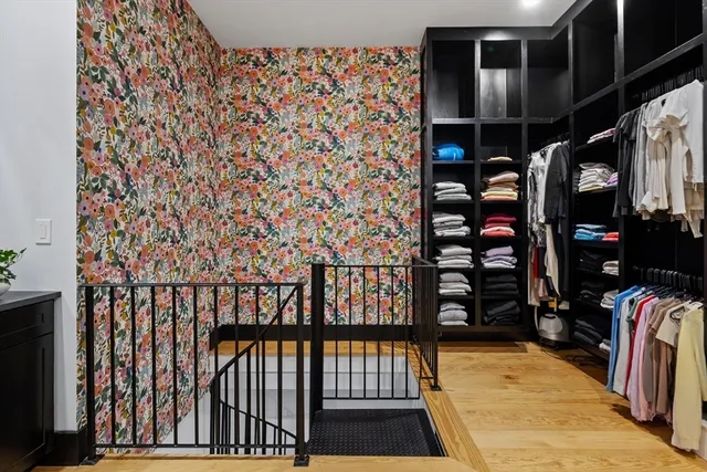 a view of walk in closet with clothes and shoes