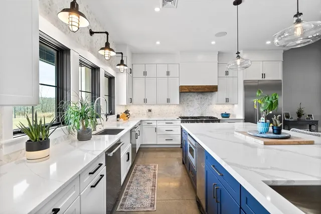 a kitchen with kitchen island granite countertop a sink a counter top space and cabinets