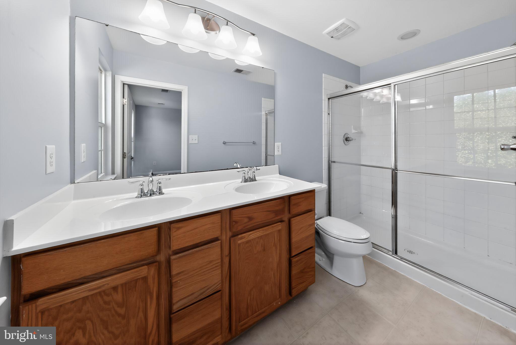 633 Barrie Road Middletown, DE 19709 - Photo 15 of 15 a bathroom with a toilet sink double vanity and mirror