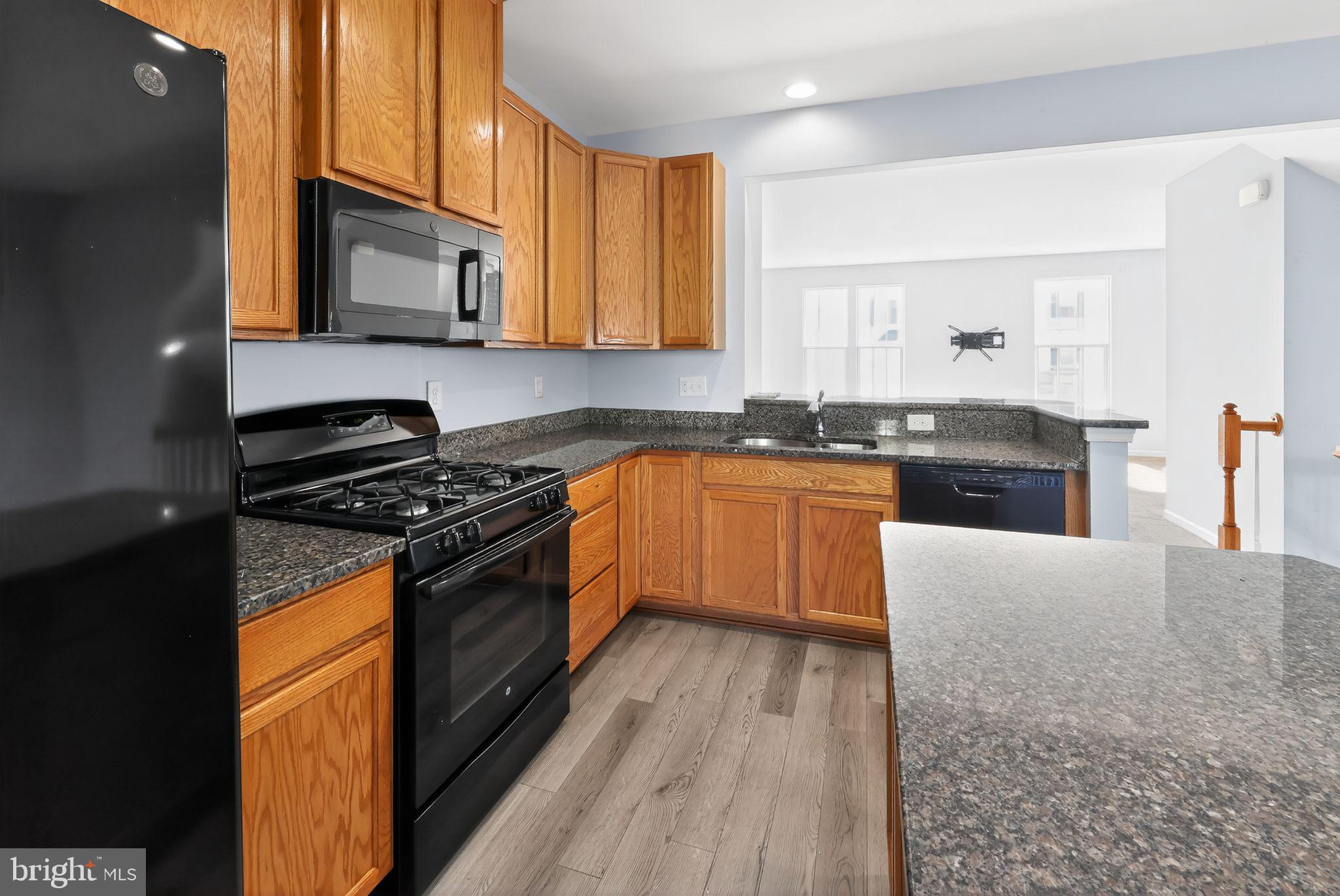 633 Barrie Road Middletown, DE 19709 - Photo 7 of 15 a kitchen with stainless steel appliances granite countertop a stove a sink and a microwave