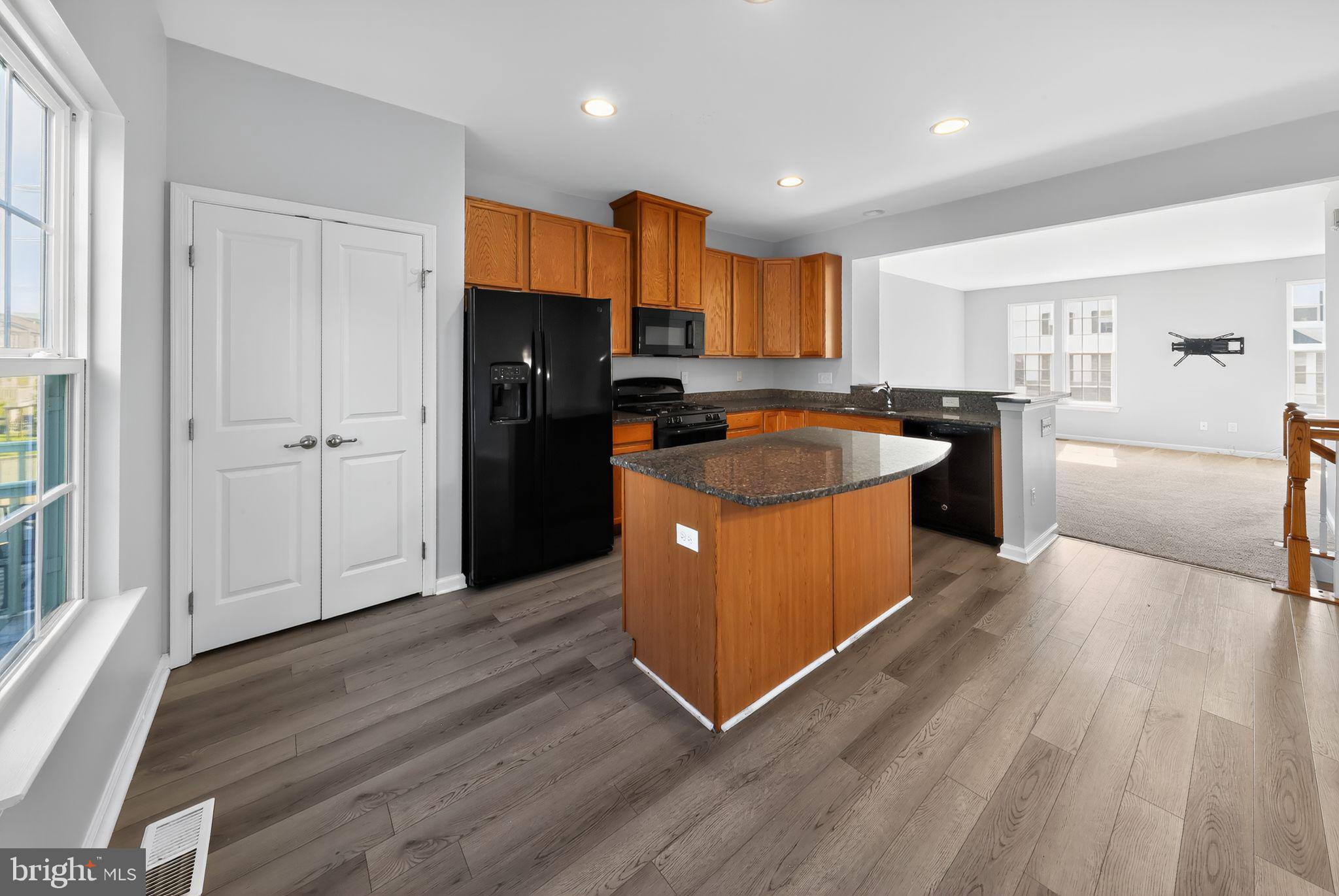 633 Barrie Road Middletown, DE 19709 - Photo 8 of 15 a kitchen with wooden floors and wooden cabinets