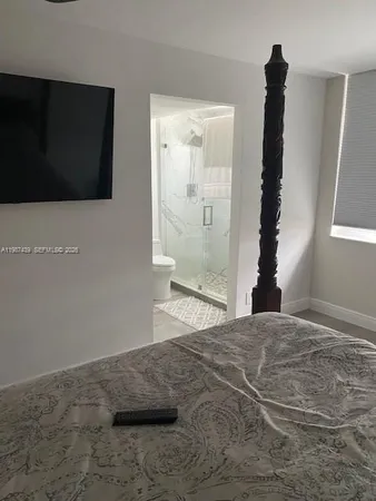 a bed sitting in a bedroom next to a lamp