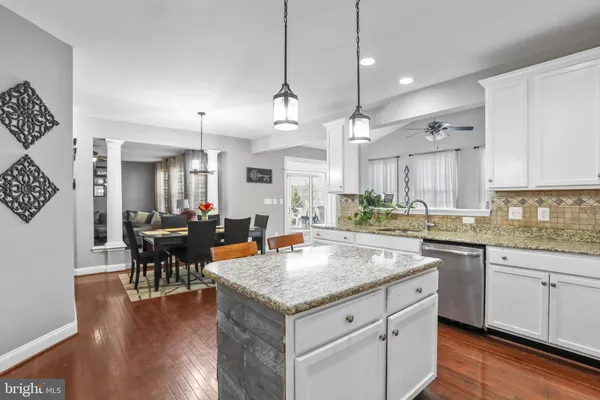 a kitchen with stainless steel appliances granite countertop a stove a sink refrigerator and a wooden floor