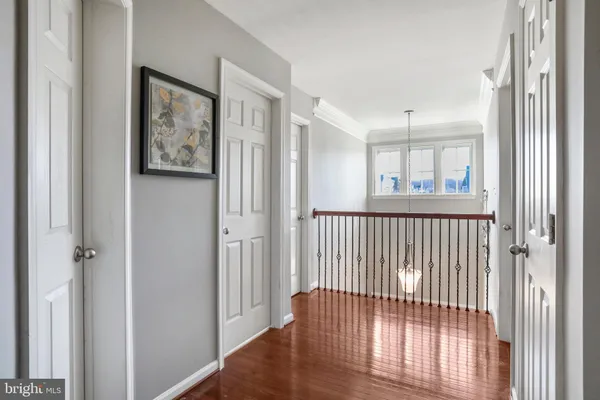 a view of a hallway with wooden floor and closet area