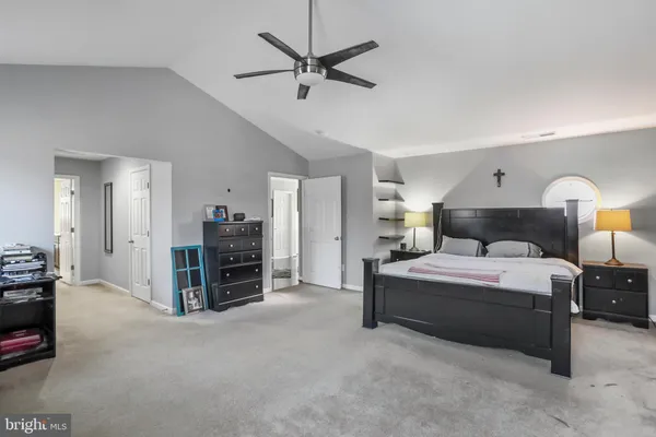 a bedroom with a bed dresser and a flat tv screen