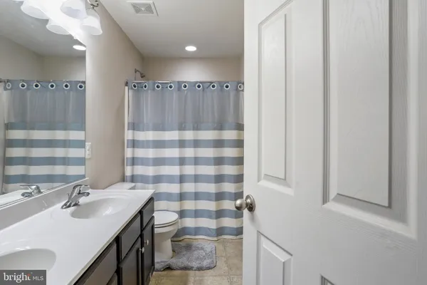 a bathroom with a sink a toilet a shower and a mirror