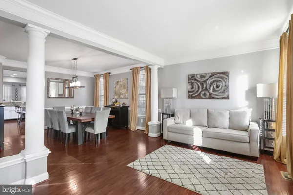 a living room with furniture wooden floor and a dining table