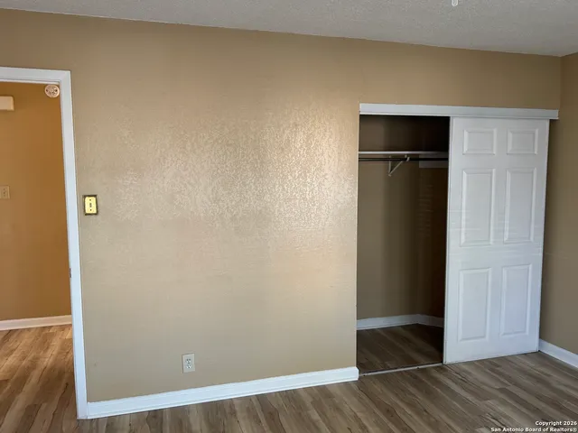 an empty room with wooden floor and closet