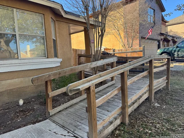 a view of a house with backyard and wooden fence