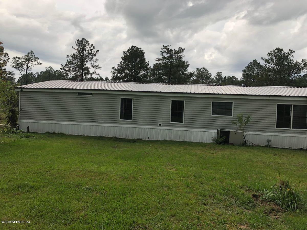54254 Heller Road Callahan, FL 32011 - Photo 21 of 25 a backyard of a house with lots of green space and garden