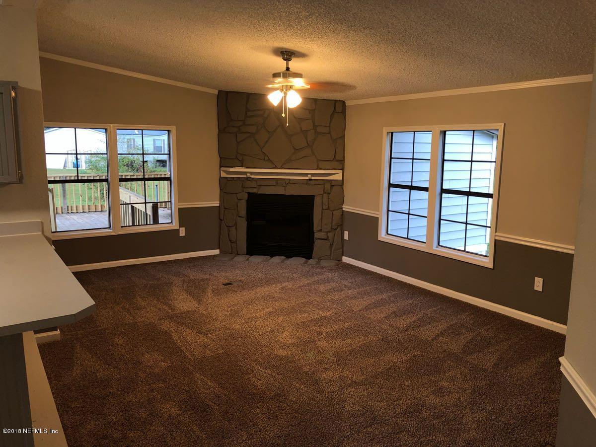 54254 Heller Road Callahan, FL 32011 - Photo 3 of 25 a view of an empty room with a fireplace and a window