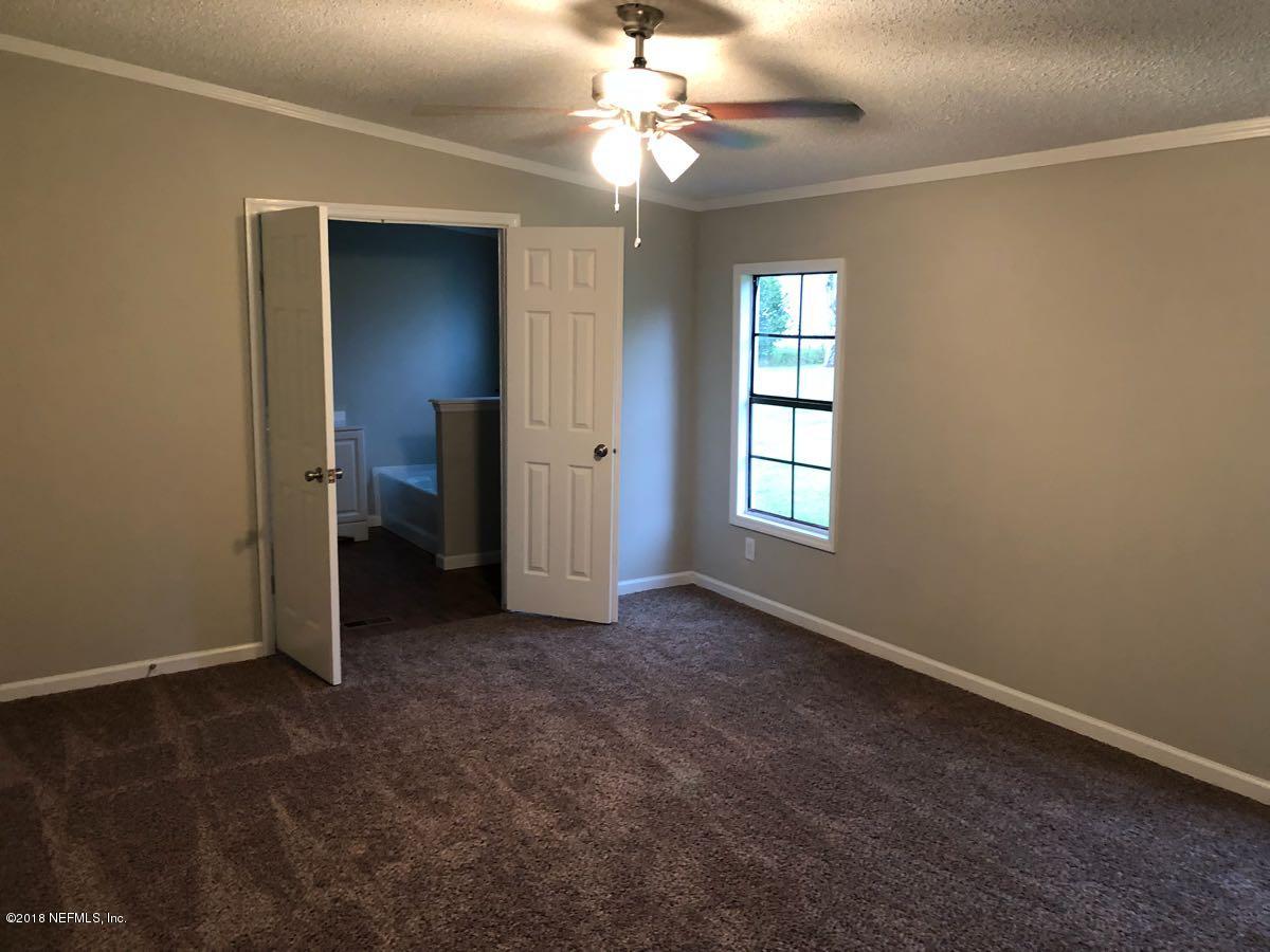 54254 Heller Road Callahan, FL 32011 - Photo 9 of 25 an empty room with closet and a chandelier fan