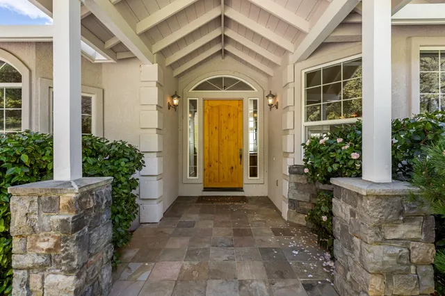 a view of a dining room with furniture large windows and a chandelier