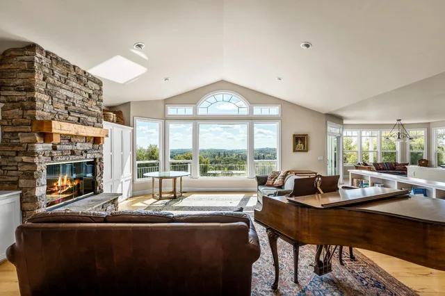 a living room with fireplace furniture and a large window