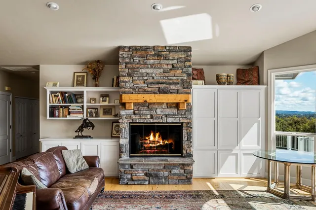 a living room with fireplace furniture and a large window