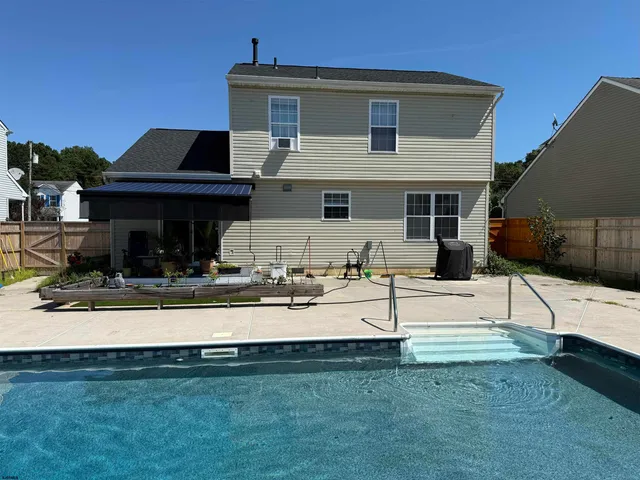 a view of a house with backyard and sitting area