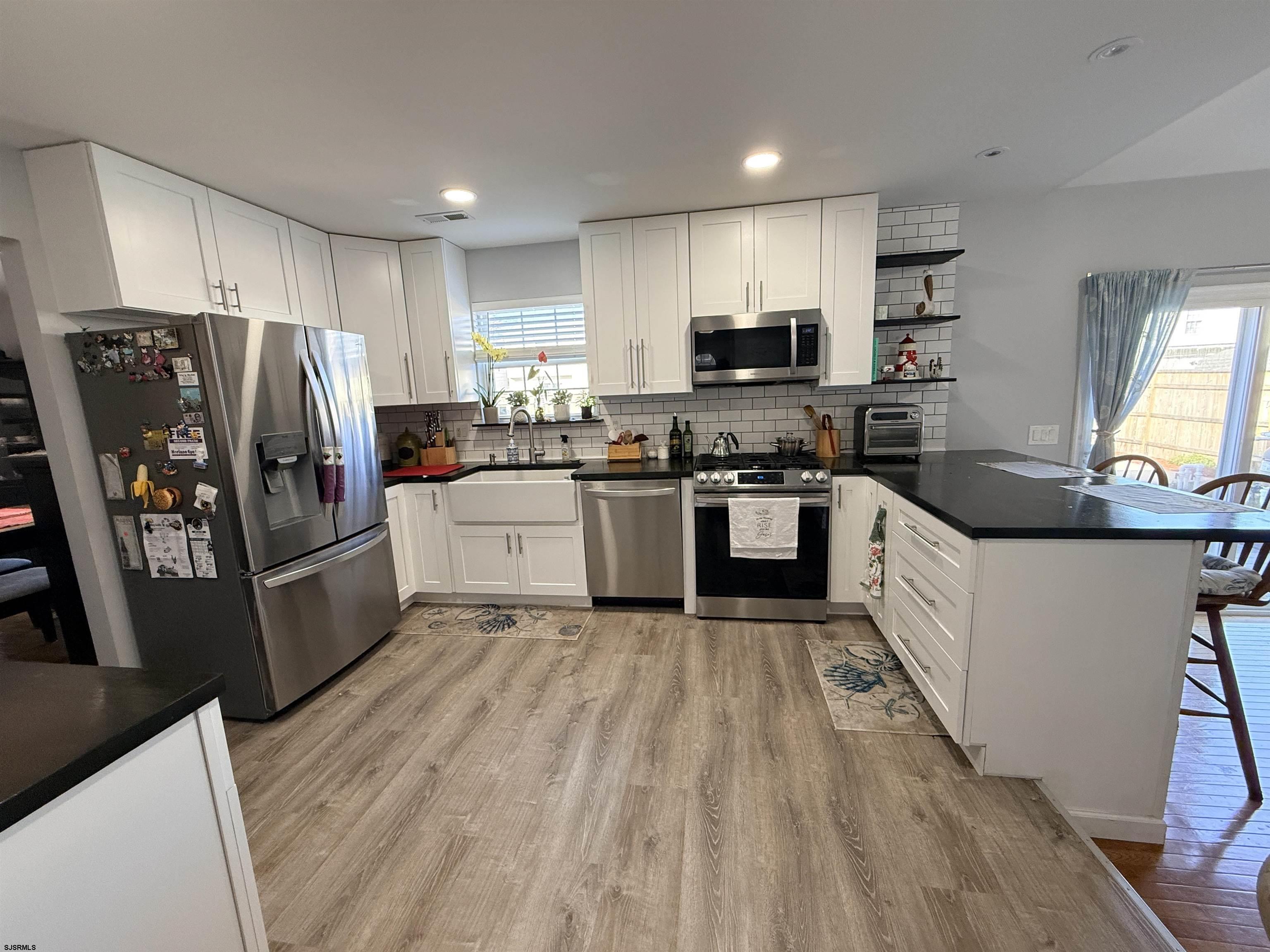477 Damson Avenue Galloway Township, NJ 08205 - Photo 5 of 24 a large kitchen with a stove a sink dishwasher a refrigerator and a oven with wooden floor