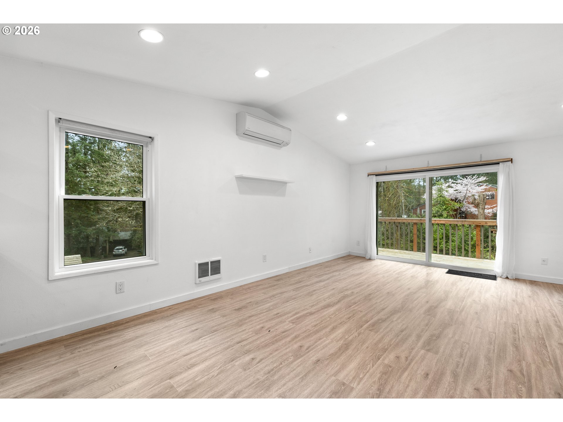 4594 Southwest Caldew Street, Unit A Portland, OR 97219 - Photo 12 of 29 an empty room with wooden floor and windows