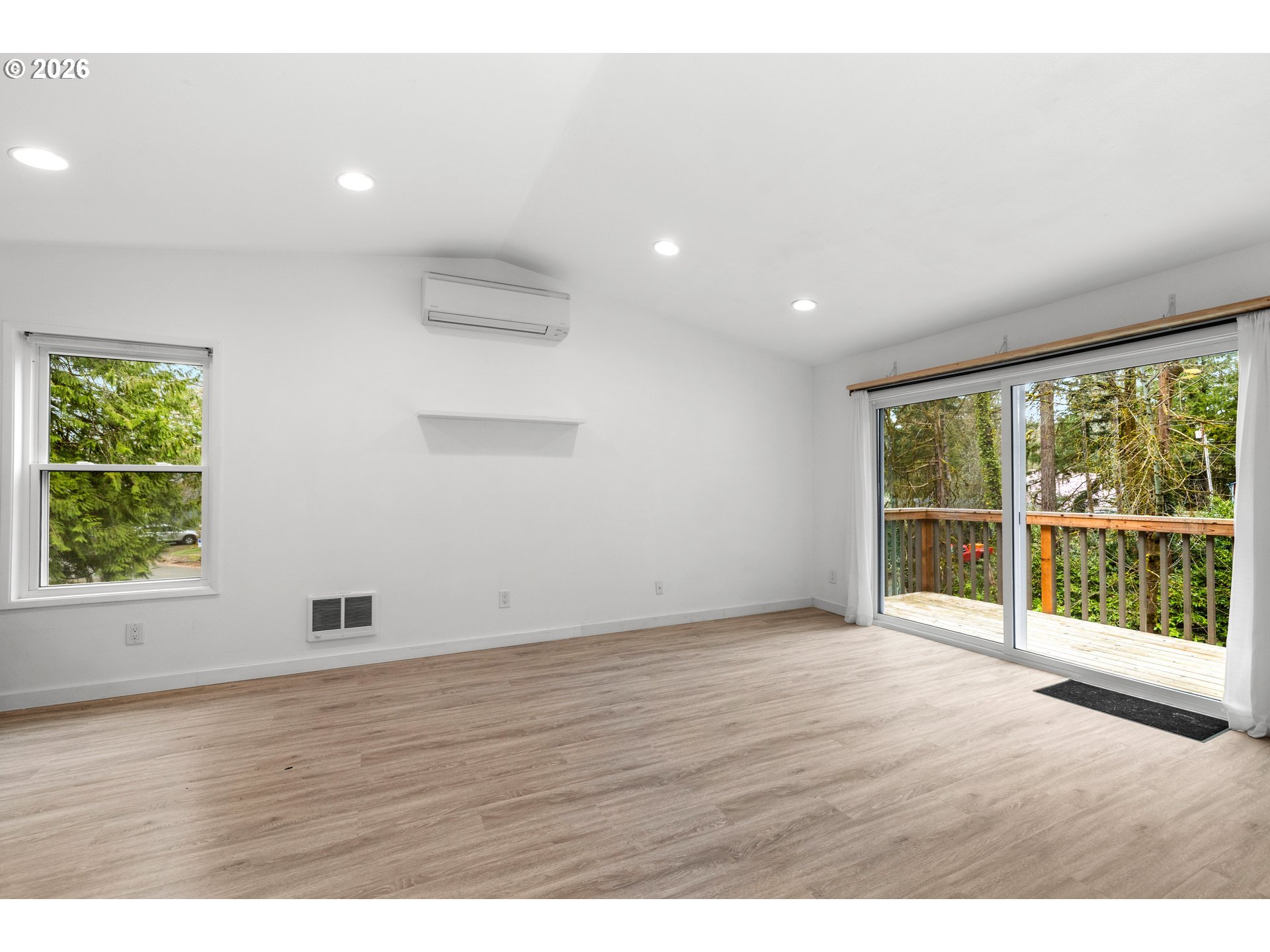 4594 Southwest Caldew Street, Unit A Portland, OR 97219 - Photo 13 of 29 an empty room with wooden floor and windows