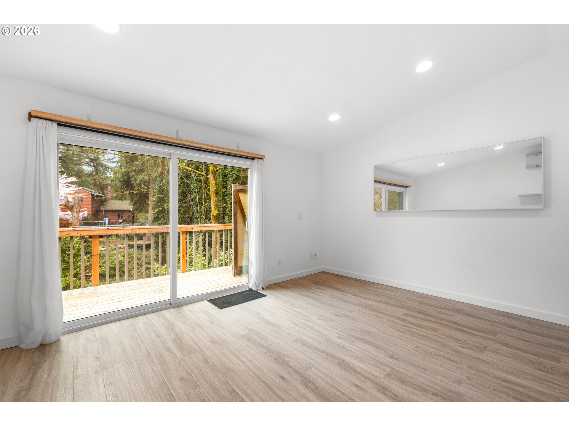 4594 Southwest Caldew Street, Unit A Portland, OR 97219 - Photo 14 of 29 a view of an empty room with wooden floor and a window