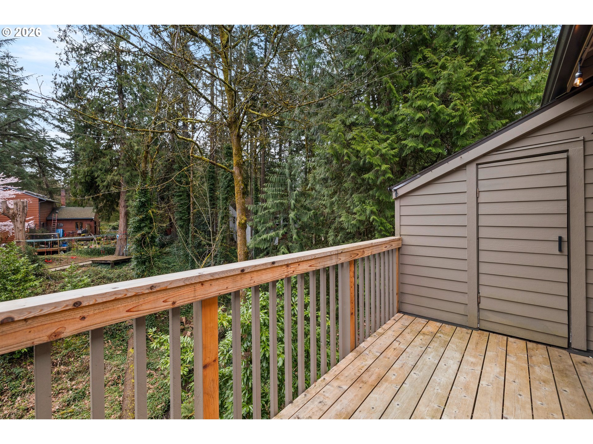 4594 Southwest Caldew Street, Unit A Portland, OR 97219 - Photo 24 of 29 a balcony with wooden floor and fence