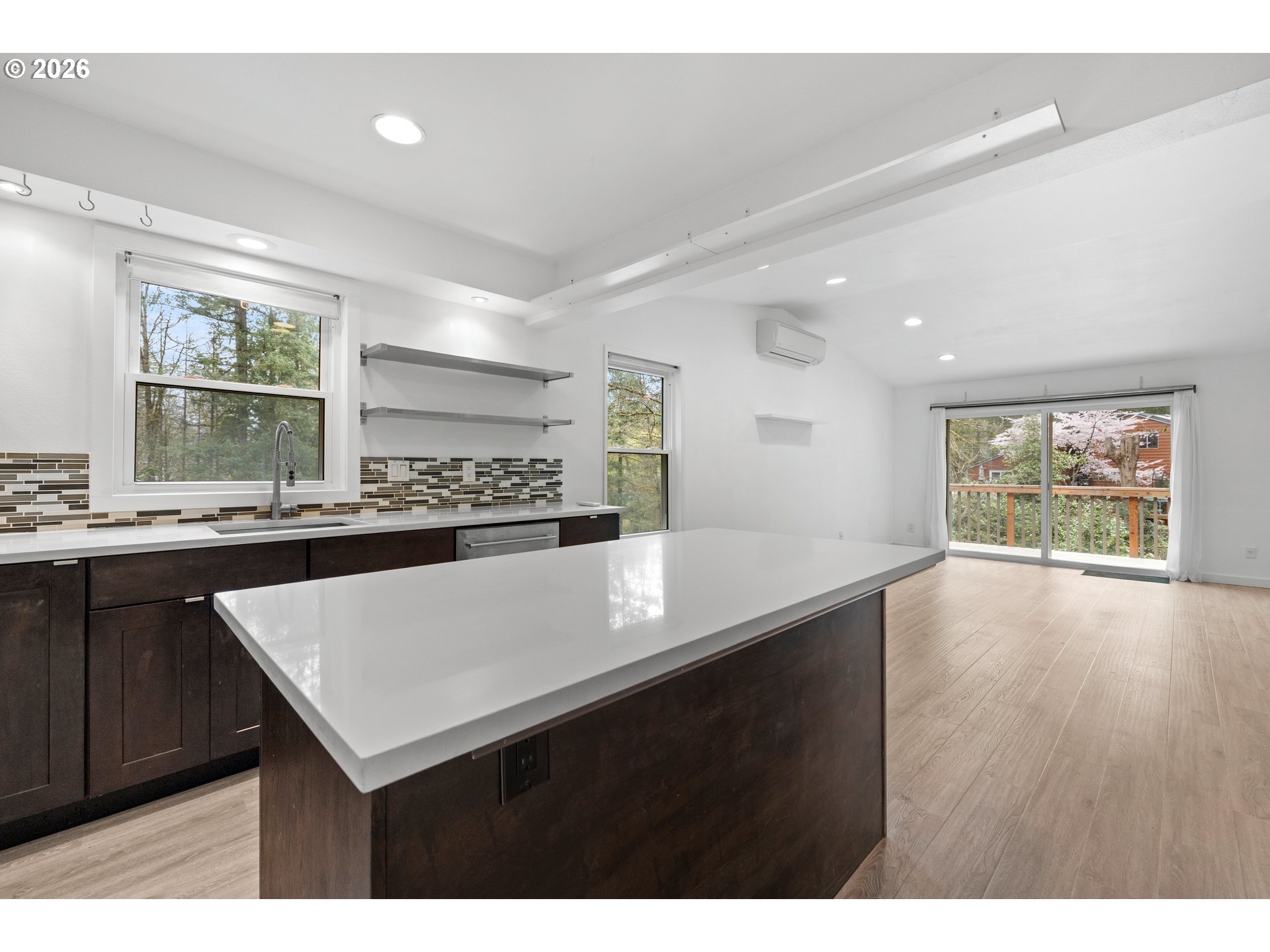 4594 Southwest Caldew Street, Unit A Portland, OR 97219 - Photo 4 of 29 a kitchen with stainless steel appliances granite countertop a sink window and wooden floor