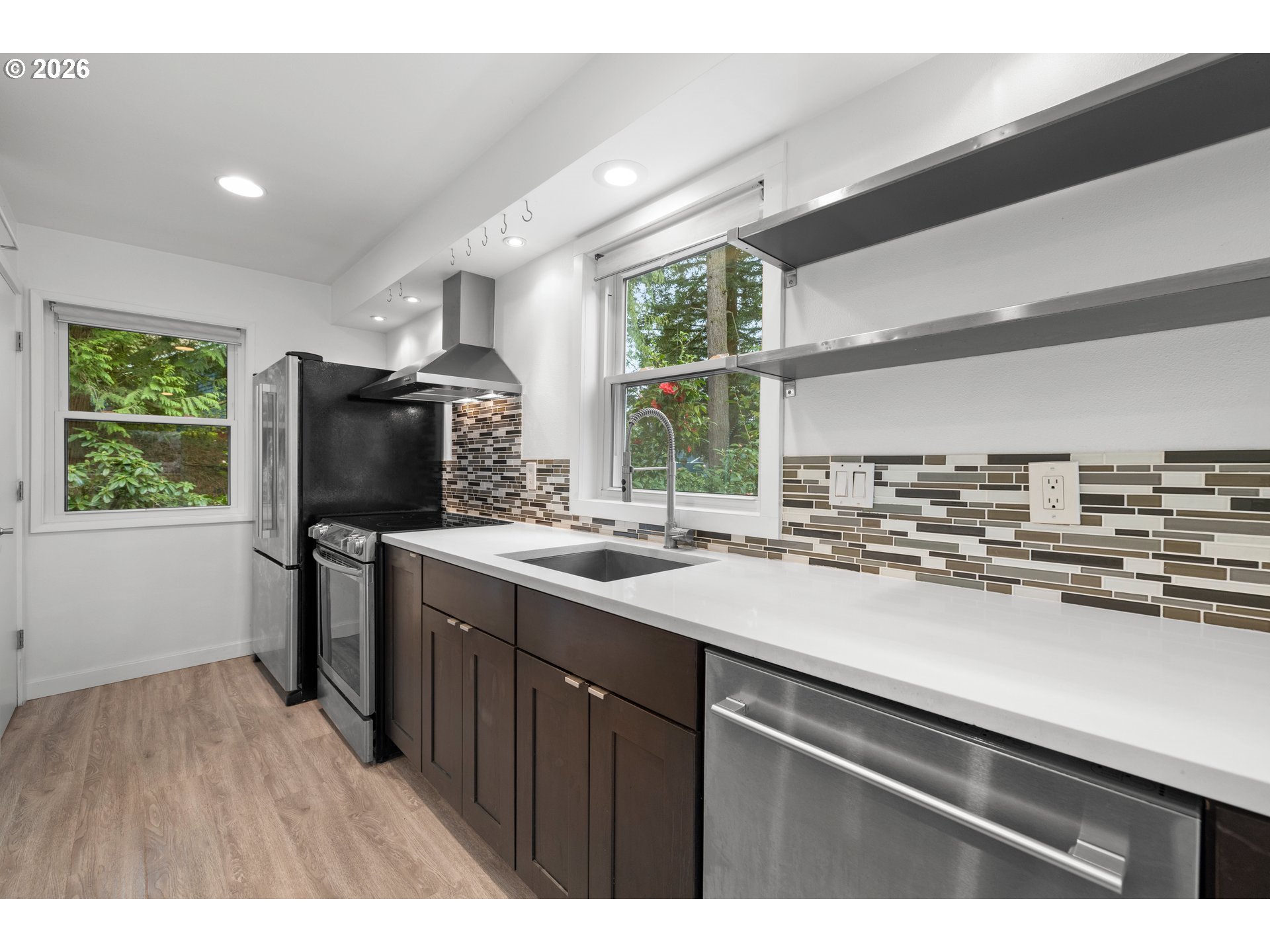 4594 Southwest Caldew Street, Unit A Portland, OR 97219 - Photo 6 of 29 a kitchen with a sink a counter top space and stainless steel appliances