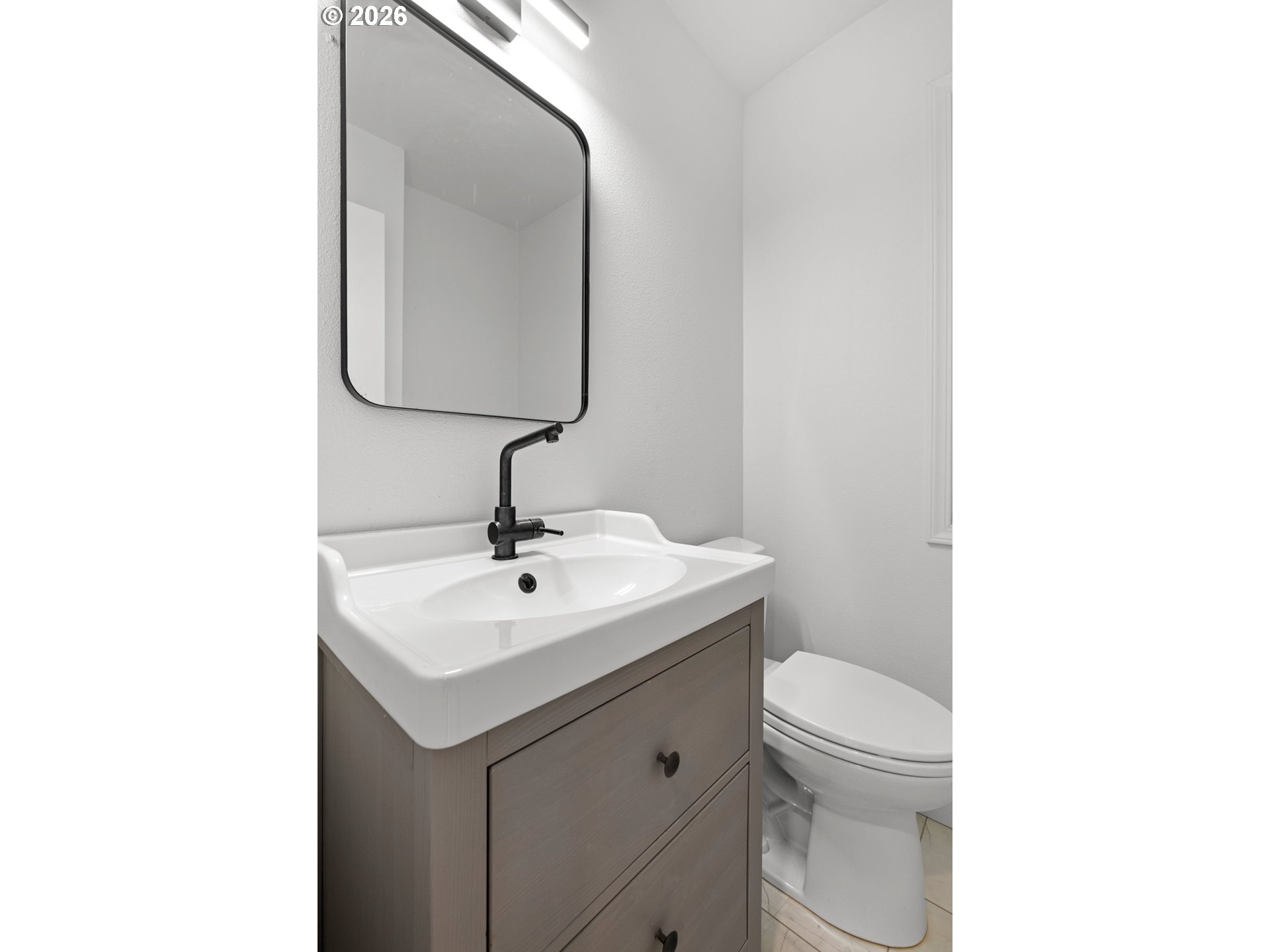 4594 Southwest Caldew Street, Unit A Portland, OR 97219 - Photo 10 of 29 a bathroom with a toilet sink and mirror