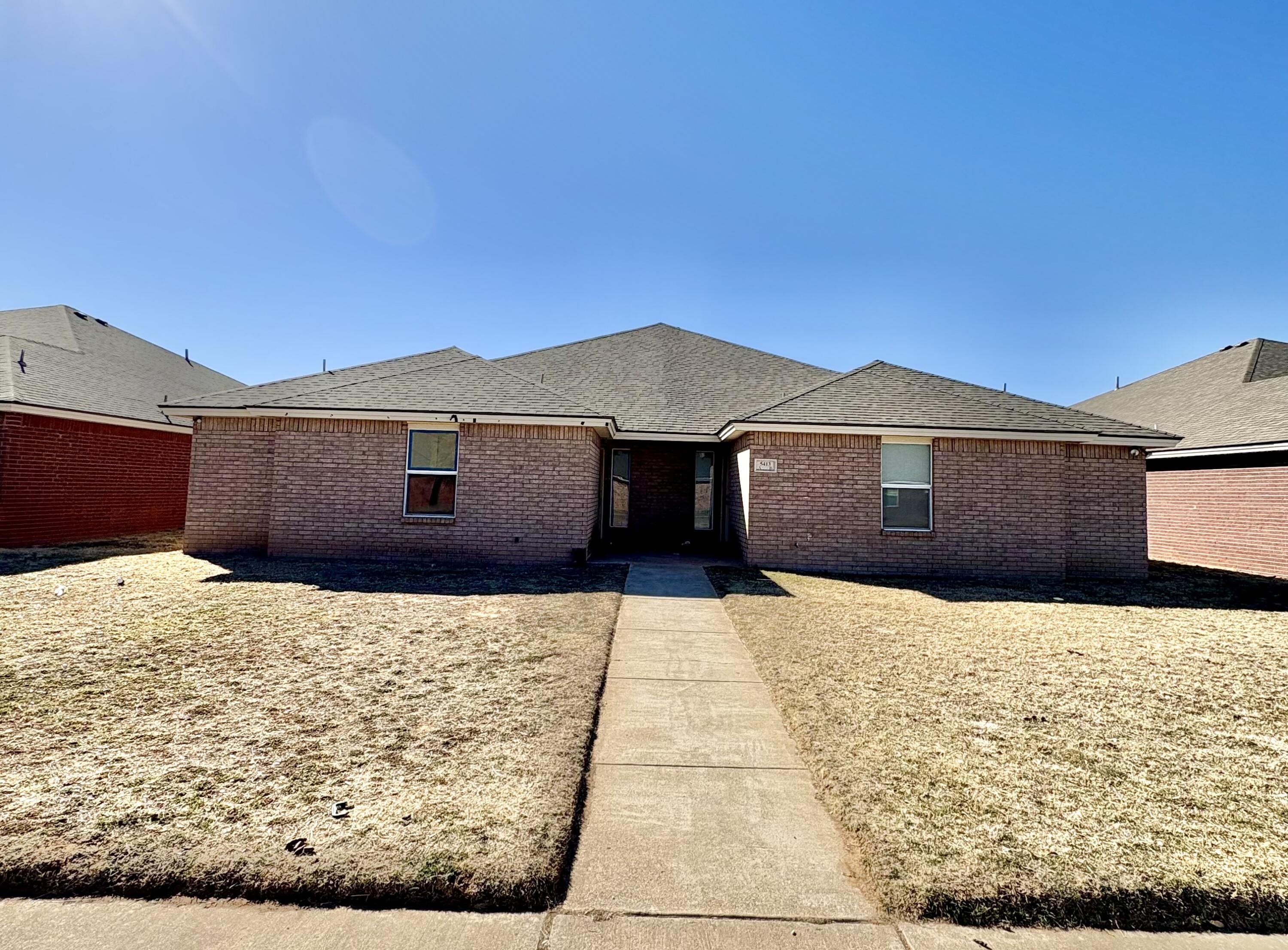 5413 Harvard Street, Unit B Lubbock, TX 79416 - Photo 1 of 10 a front view of a house with a yard and garage