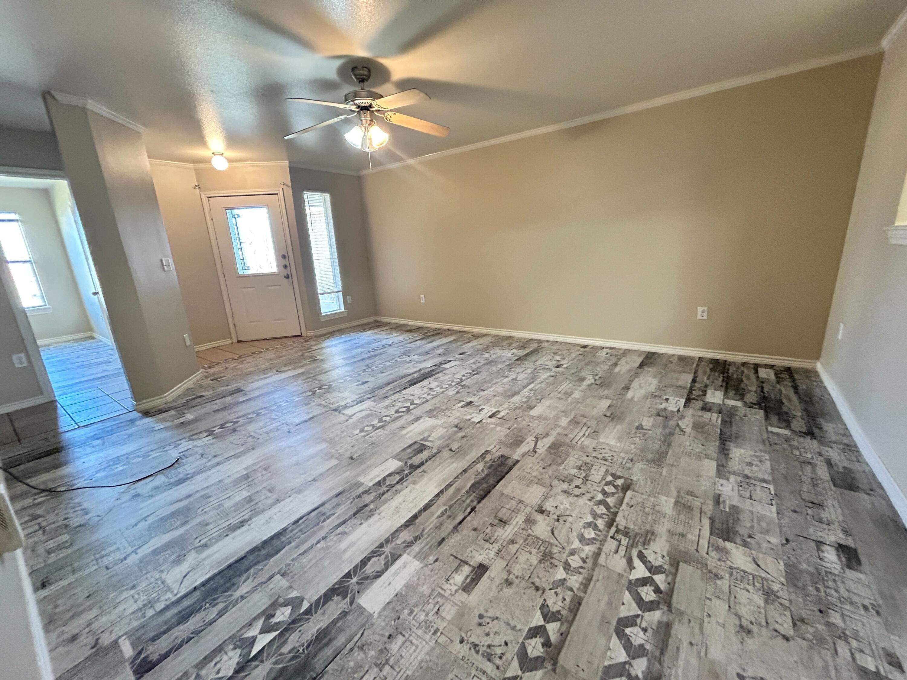 5413 Harvard Street, Unit B Lubbock, TX 79416 - Photo 2 of 10 a view of an empty room with window and wooden floor